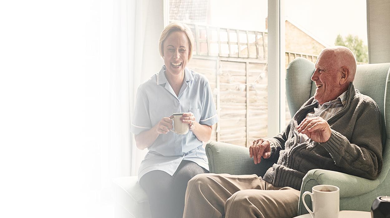 assisted living father and daughter enjoying cups of tea and coffee The Delaney at Georgetown