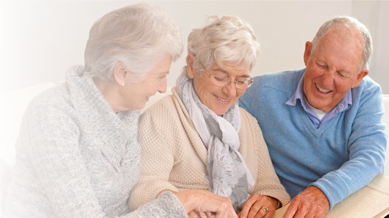 elderly women and man looking through picture books and events at The Delaney at Georgetown