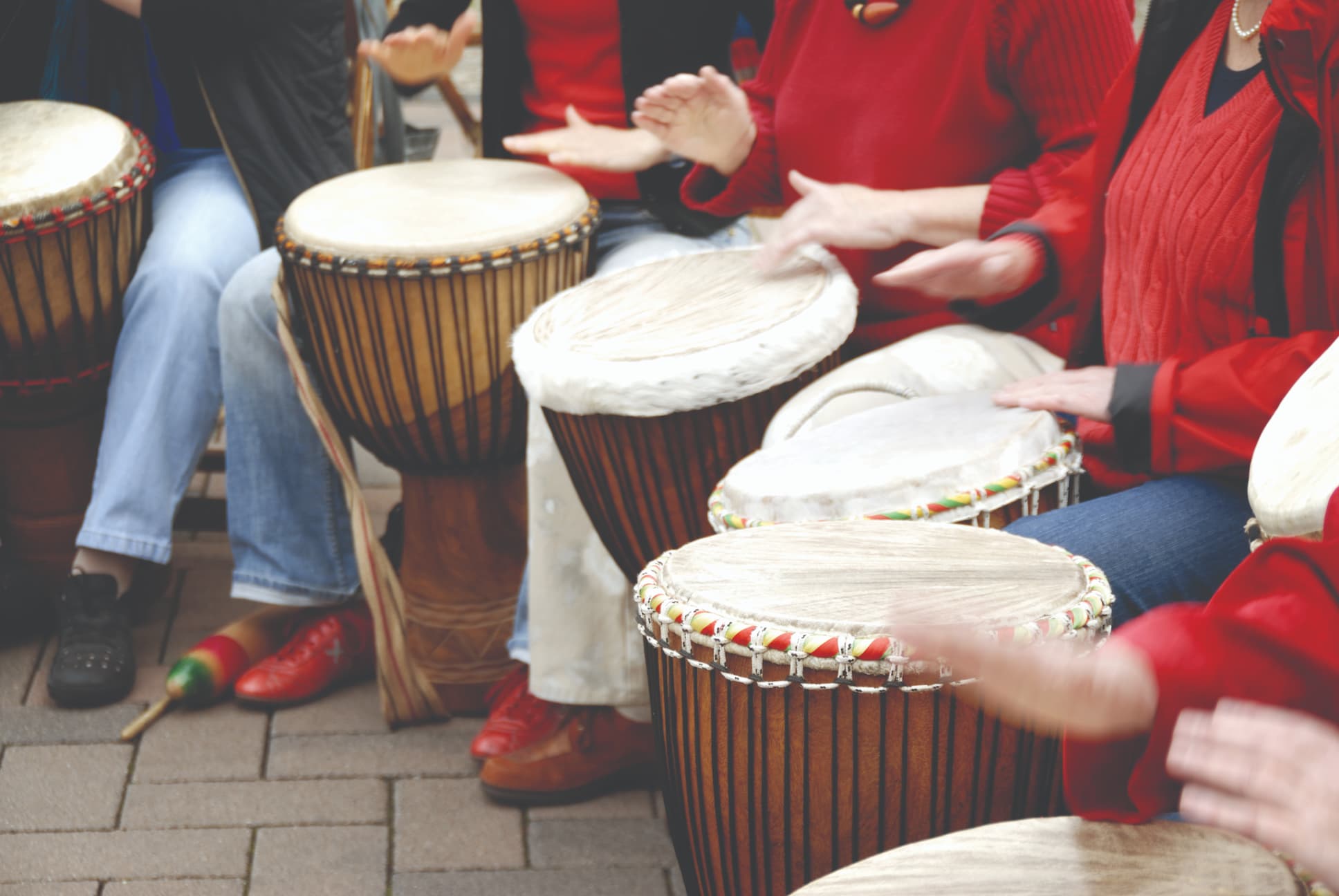 close up of a group of people playing the bongos