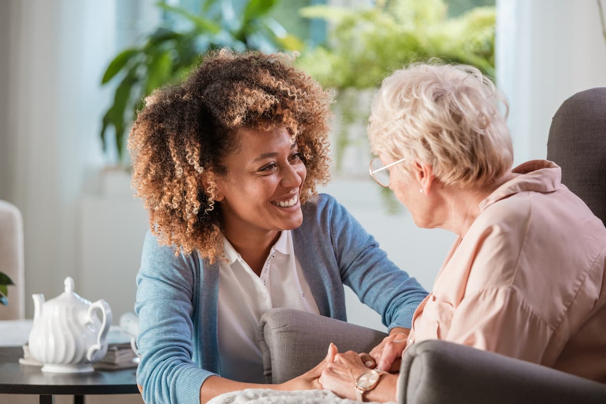 Nurse leaning in to check on senior woman